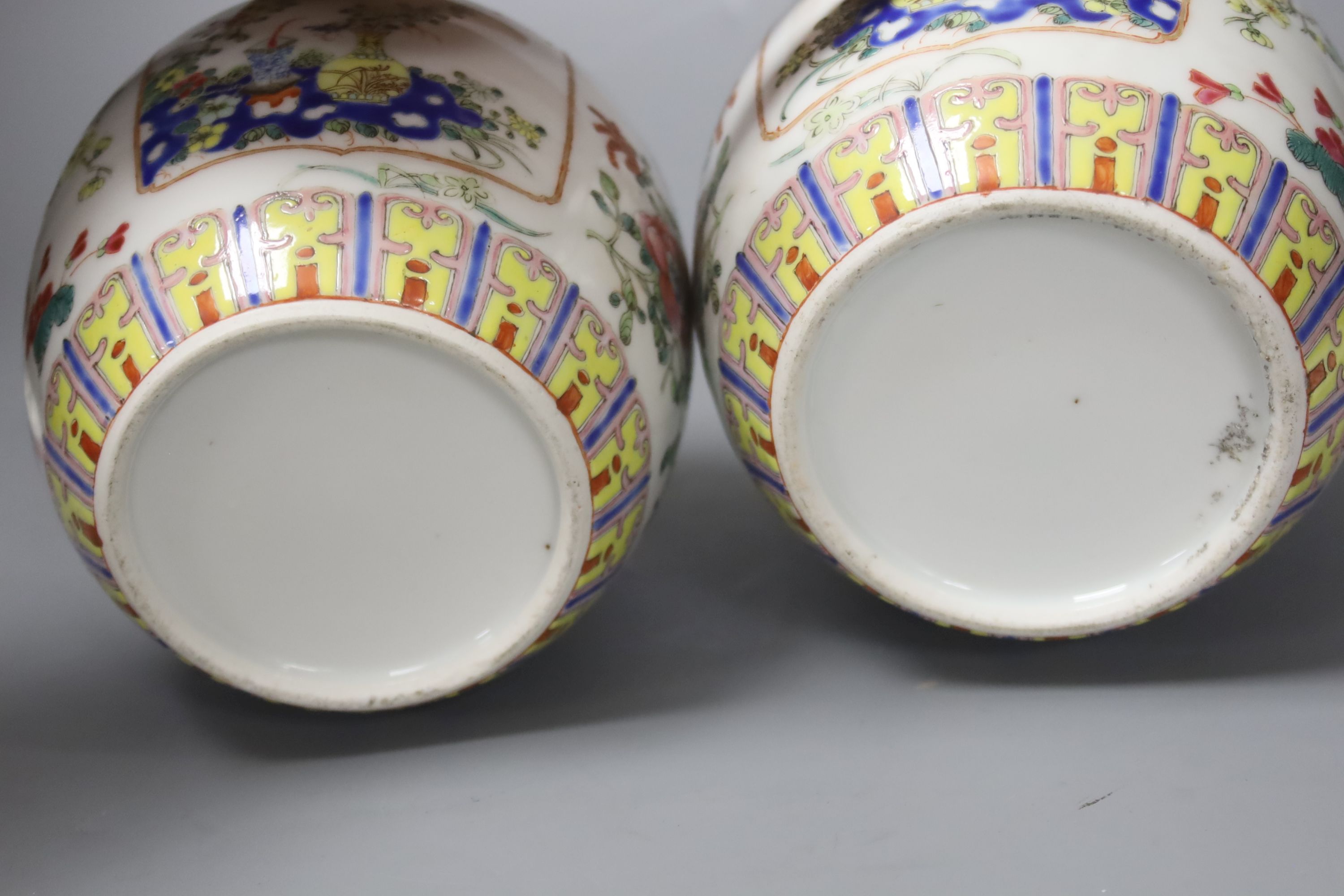 A pair of Chinese famille rose jars and covers, late 19/early 20th century, 15.5cm, on hardwood stands